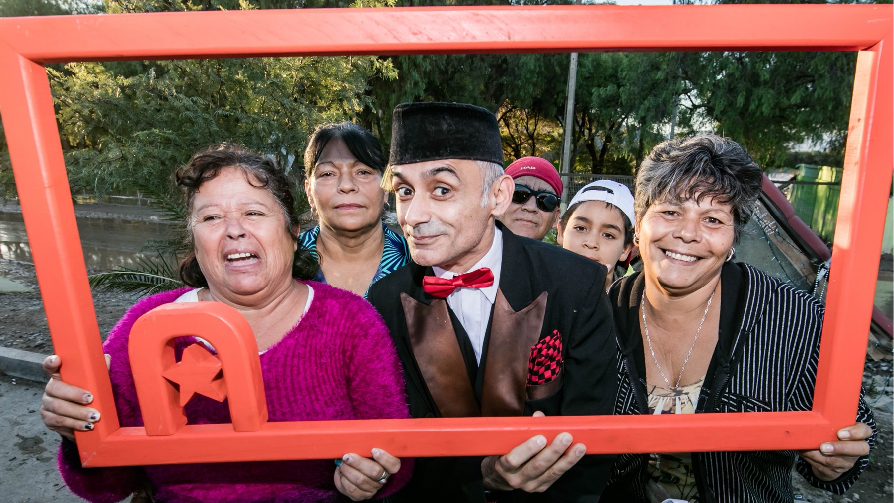 Artista y vecinos posan juntos tras una actividad comunitaria