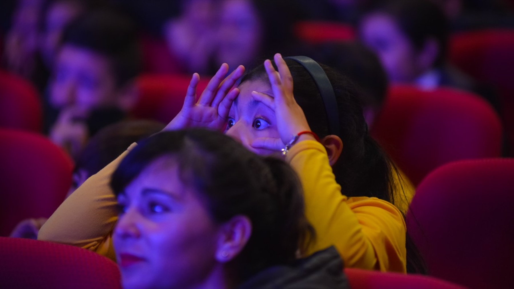 Niña observa con asombro desde el público