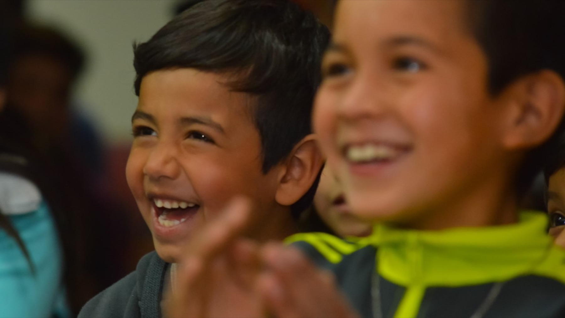 Niño sonríe mientras mira una presentación