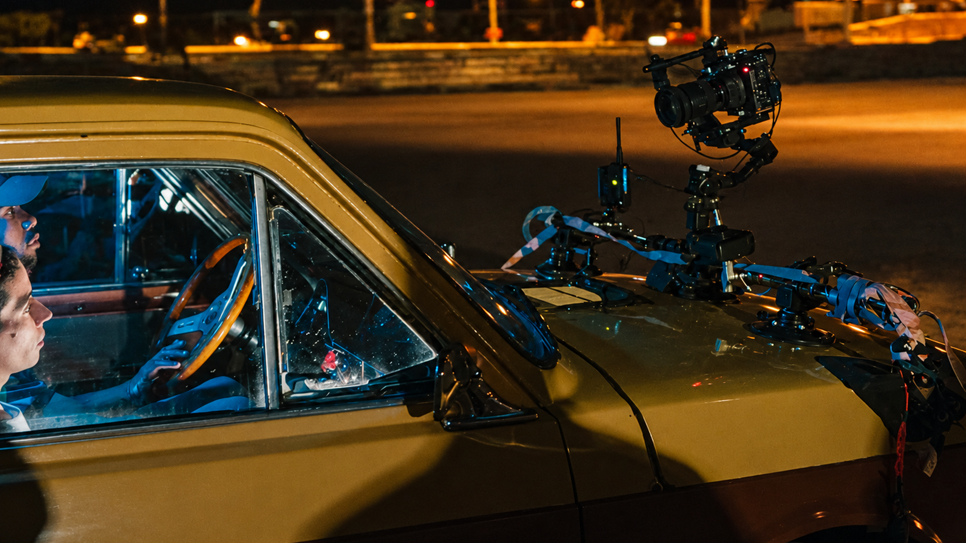 Equipo de rodaje junto a un automóvil durante la noche